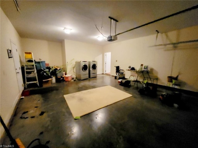 garage with a garage door opener and independent washer and dryer