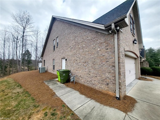 view of property exterior featuring cooling unit and a garage