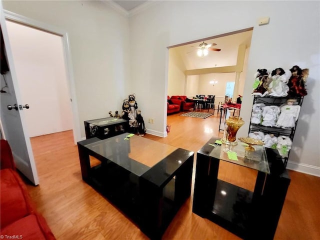 living room with ornamental molding, light hardwood / wood-style floors, and ceiling fan