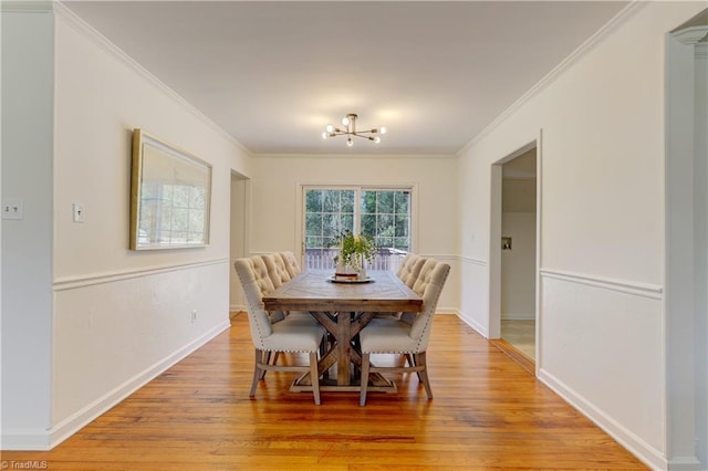 dining space with a notable chandelier, crown molding, and light hardwood / wood-style floors