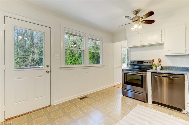 kitchen featuring ceiling fan, appliances with stainless steel finishes, backsplash, and white cabinets