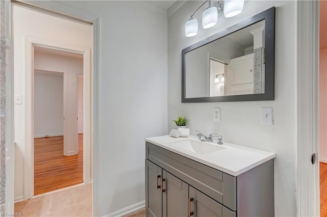 bathroom with tile patterned flooring, ornamental molding, and vanity