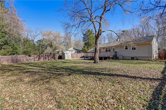 view of yard with a deck and a storage shed