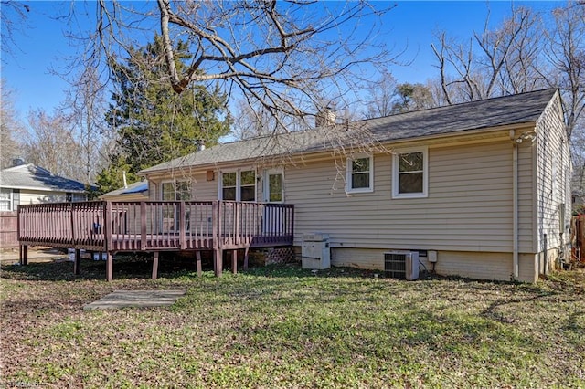 rear view of property featuring a lawn, cooling unit, and a deck