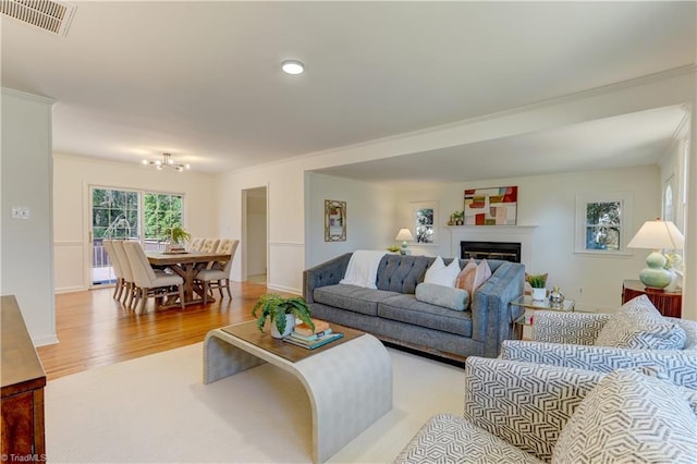 living room featuring crown molding and light hardwood / wood-style floors