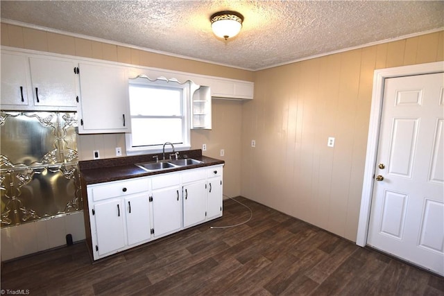 kitchen with white cabinetry, dark hardwood / wood-style flooring, sink, and a textured ceiling