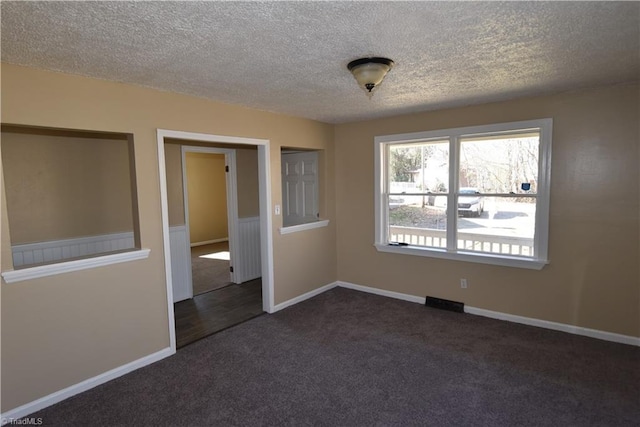 carpeted spare room with a textured ceiling