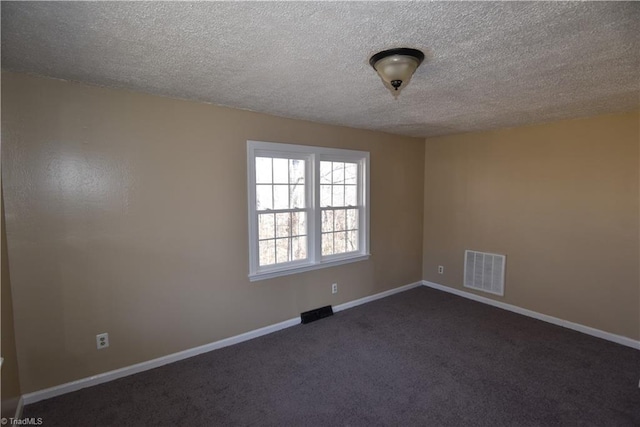 carpeted empty room with a textured ceiling