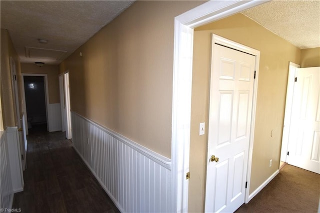 hallway featuring dark hardwood / wood-style flooring and a textured ceiling