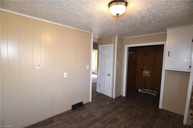 unfurnished bedroom featuring crown molding, dark hardwood / wood-style flooring, and a textured ceiling