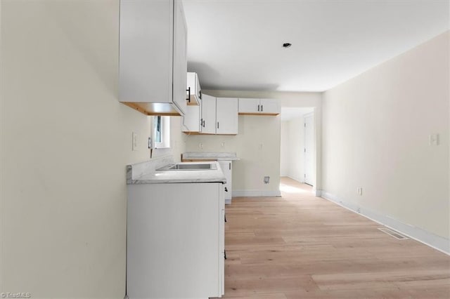 kitchen with white cabinetry and light wood-type flooring