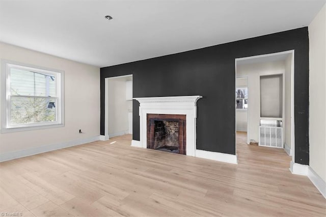 unfurnished living room with a healthy amount of sunlight and light hardwood / wood-style floors