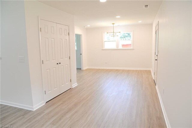 unfurnished room featuring light hardwood / wood-style flooring and a notable chandelier