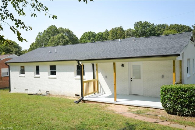 back of house with a patio area and a lawn