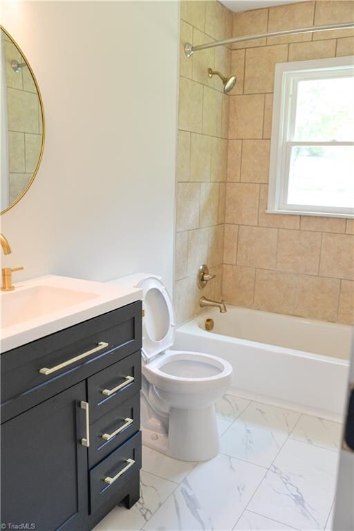 full bathroom with vanity, toilet, and tiled shower / bath combo