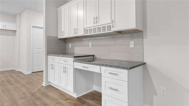 233 Lisa Ln, Winston-Salem, NC 27107 - kitchen with dark stone countertops, light wood-style floors, white cabinetry, backsplash, and baseboards