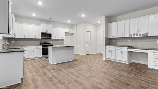 233 Lisa Ln, Winston-Salem, NC 27107 - kitchen with appliances with stainless steel finishes, a sink, decorative backsplash, light wood-style flooring, and recessed lighting