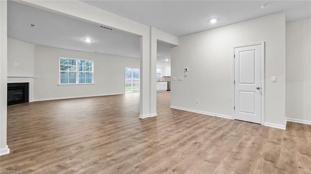233 Lisa Ln, Winston-Salem, NC 27107 - unfurnished living room with wood finished floors, a glass covered fireplace, baseboards, and recessed lighting