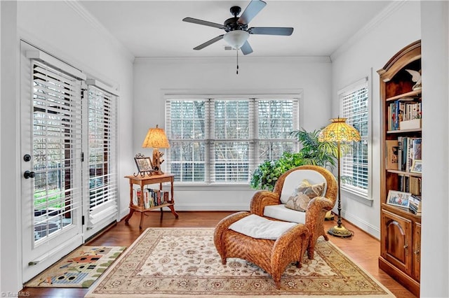 living area featuring crown molding, ceiling fan, and hardwood / wood-style flooring