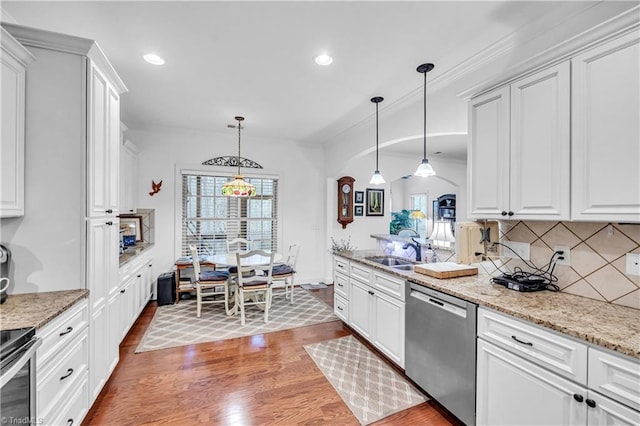 kitchen with white cabinets, decorative light fixtures, sink, and stainless steel appliances