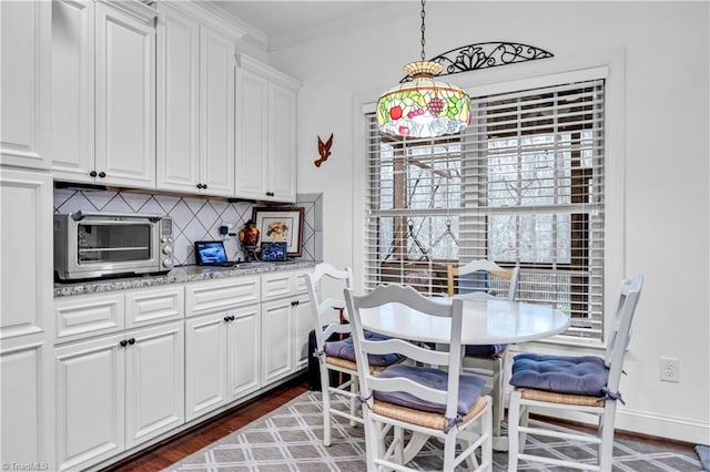 dining room featuring breakfast area, dark wood-type flooring, and crown molding