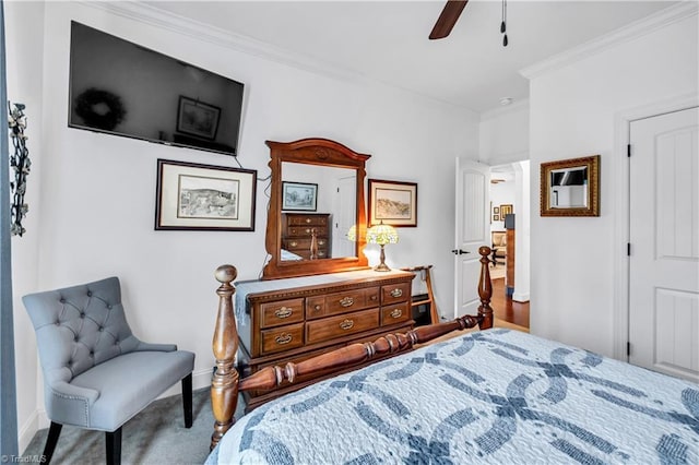 carpeted bedroom with ceiling fan and ornamental molding