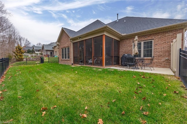 back of property featuring a yard, a patio, and a sunroom