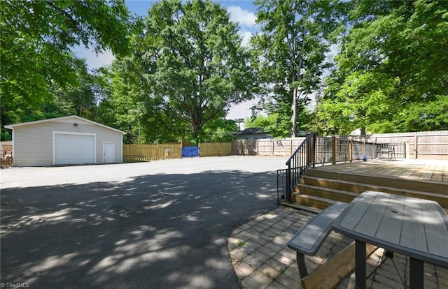 1449 NC Highway 150, Summerfield, NC 27358 - fenced backyard featuring an outbuilding, a garage, a wooden deck, and view of scattered trees