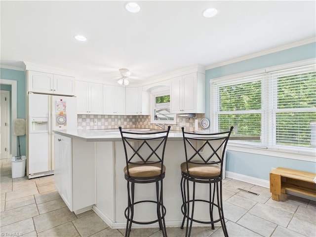 4208 Aberdare Dr, High Point, NC 27265 - kitchen with white refrigerator with ice dispenser, white cabinets, backsplash, crown molding, and recessed lighting