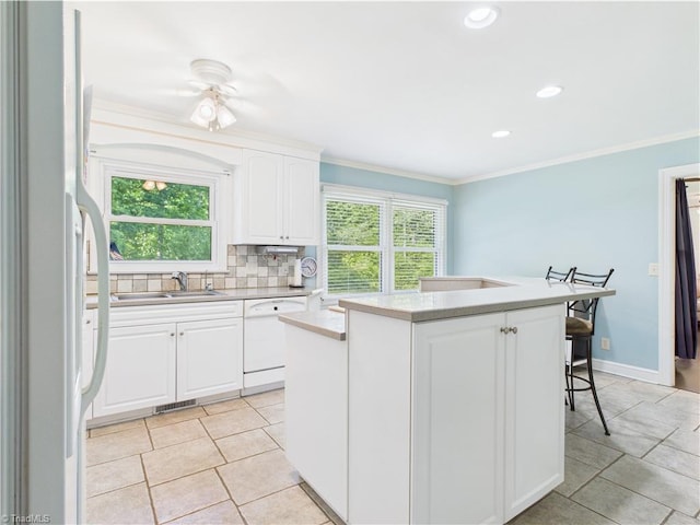 4208 Aberdare Dr, High Point, NC 27265 - kitchen with white appliances, a sink, a center island, ornamental molding, and tasteful backsplash