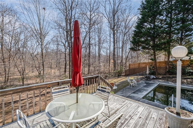 wooden terrace with outdoor dining area and fence