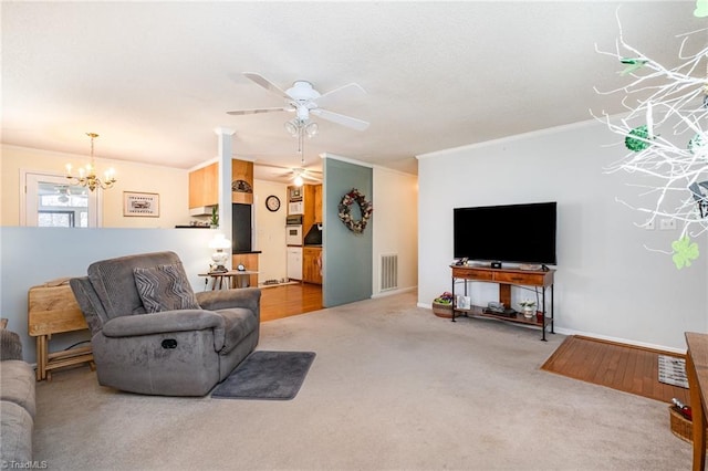 living area with visible vents, ceiling fan with notable chandelier, crown molding, and carpet