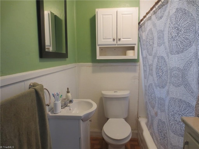 full bathroom featuring vanity, toilet, shower / tub combo, and tile walls