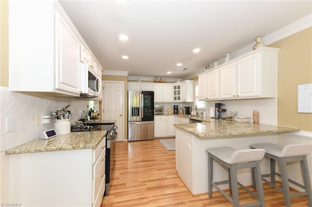 kitchen featuring stainless steel fridge with ice dispenser, white microwave, range with electric cooktop, a peninsula, and ornamental molding