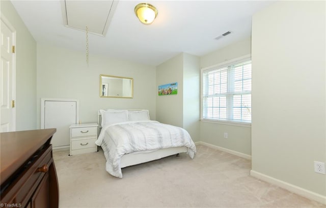 bedroom featuring light carpet, attic access, and baseboards