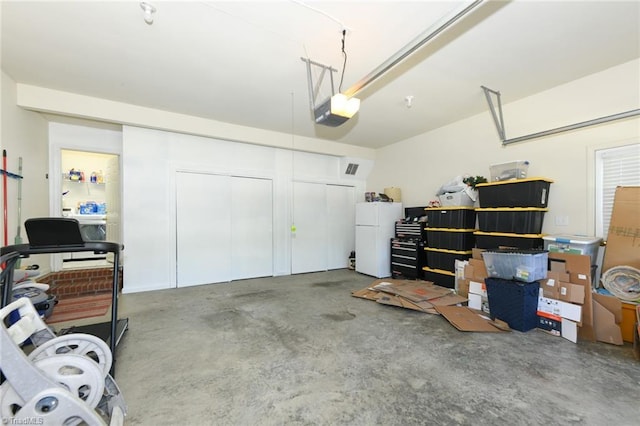garage featuring freestanding refrigerator and a garage door opener
