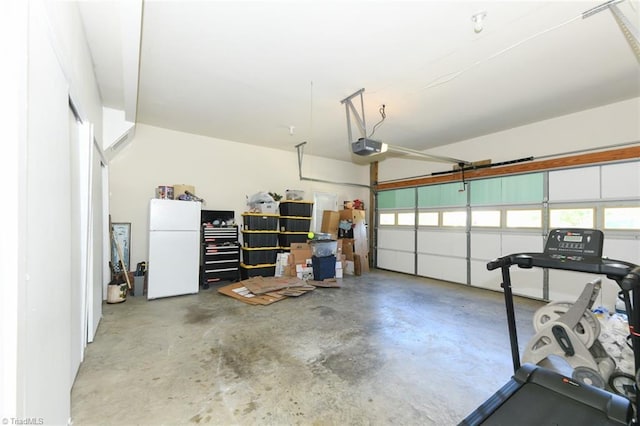 garage featuring freestanding refrigerator and a garage door opener