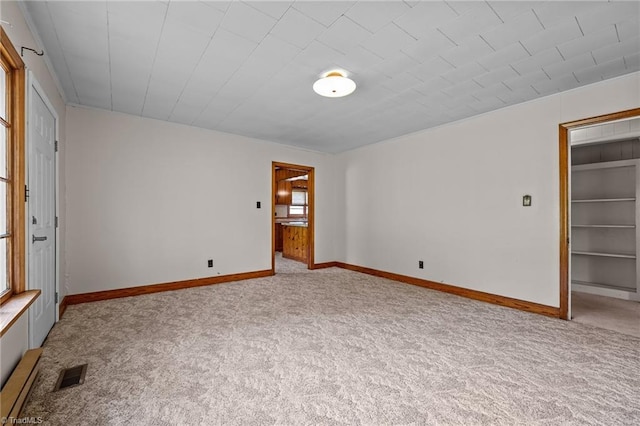 unfurnished bedroom with multiple windows, visible vents, and light carpet