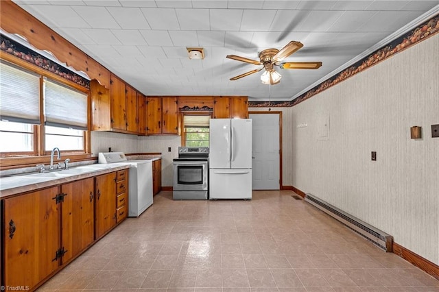 kitchen featuring a sink, stainless steel electric range oven, freestanding refrigerator, washer / clothes dryer, and a baseboard radiator