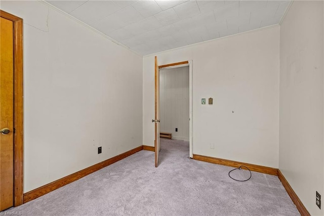 unfurnished room with baseboards, carpet, and crown molding