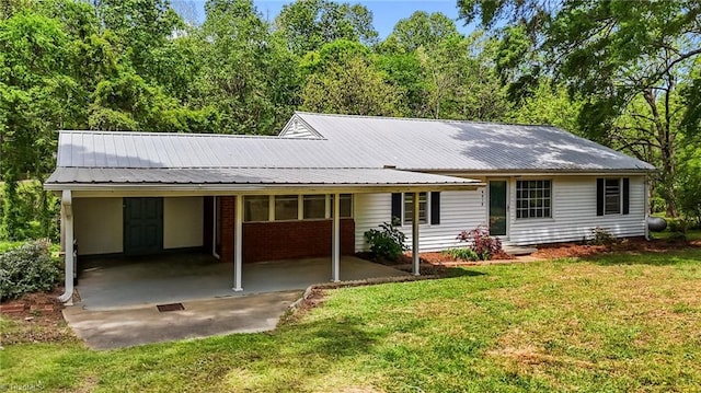 view of front of house with a carport, a front yard, and metal roof