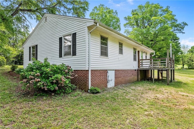 view of property exterior with a lawn and a wooden deck