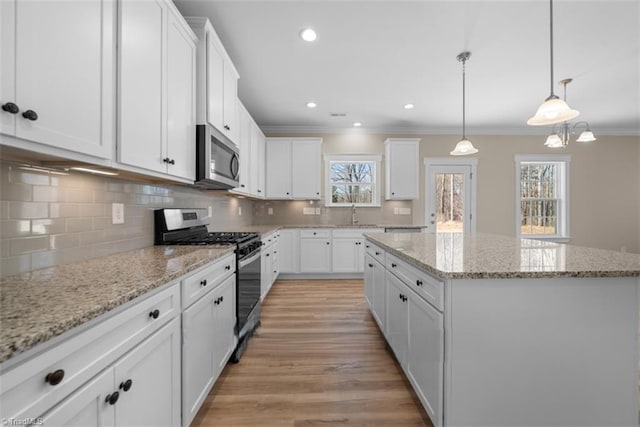 4095 Stallion St Lot 19, High Point, NC 27262 - kitchen with appliances with stainless steel finishes, a kitchen island, crown molding, white cabinetry, and decorative backsplash