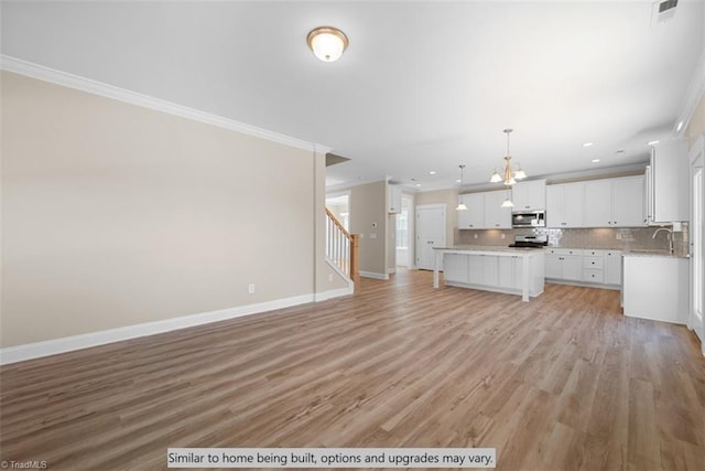 4095 Stallion St Lot 19, High Point, NC 27262 - unfurnished living room featuring crown molding, a chandelier, light wood-type flooring, stairs, and baseboards