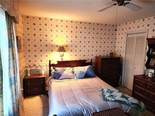 bedroom with light carpet, ceiling fan, a textured ceiling, and wallpapered walls