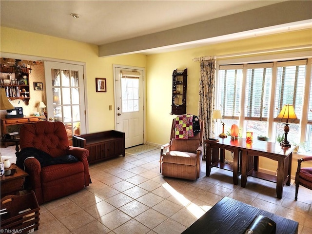 living area featuring light tile patterned floors, baseboards, and a wealth of natural light