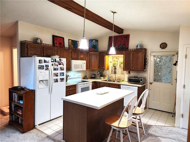 kitchen featuring a center island, decorative light fixtures, light countertops, a sink, and white appliances