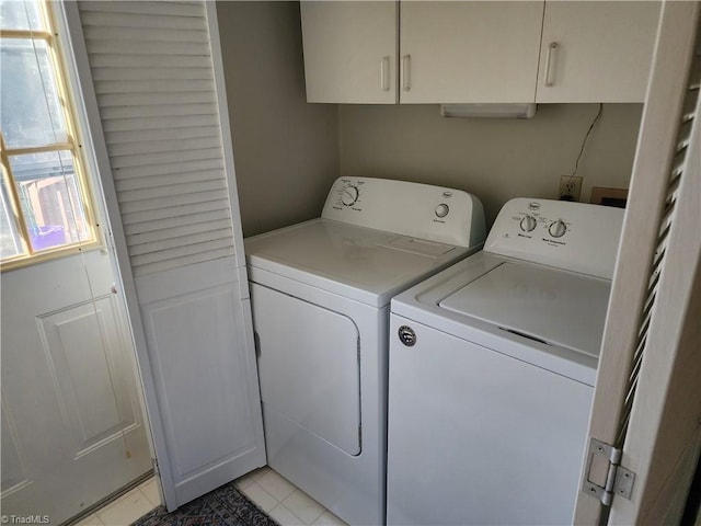 washroom with cabinet space, independent washer and dryer, and light tile patterned floors