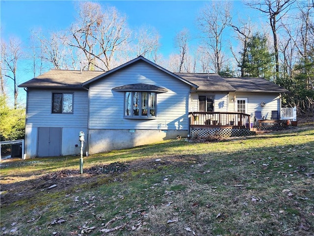 rear view of property with a yard and a deck