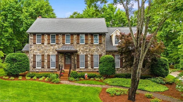 6 Yardarm Ct, Greensboro, NC 27455 - colonial inspired home featuring stone siding, a chimney, and a front lawn